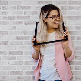 pexels-designecologist-975680 Femme tenant un cadre autour de son coup, ressortant la tête.